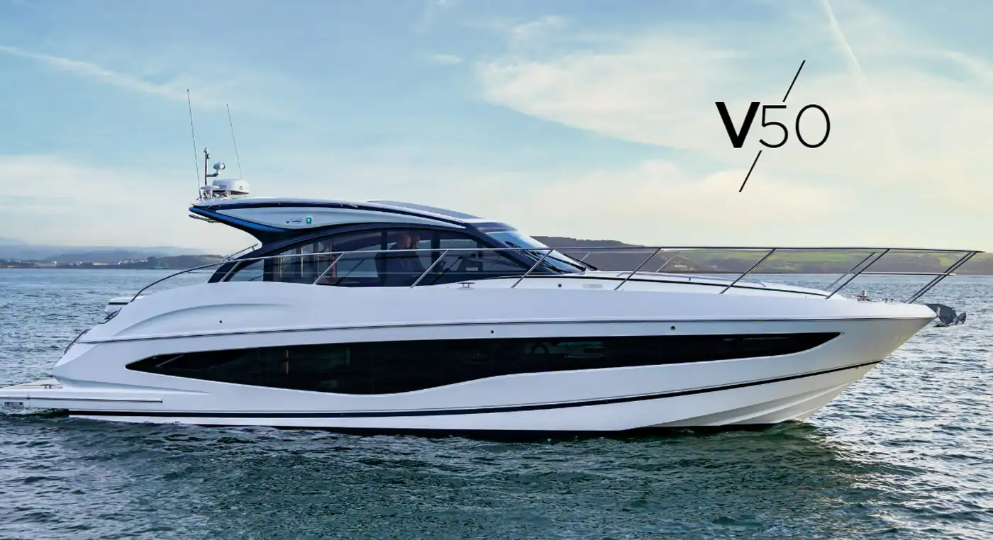 Elegant yacht Princess V50 sailing on calm waters, showcasing its sleek design against a distant shoreline.