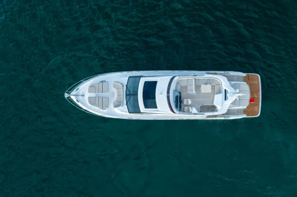 Draufsicht der Princess S65 in Bewegung auf dem Wasser, mit klarer Sicht auf das großzügige Decklayout, das Sonnendeck und die eleganten Linien des weißen Rumpfes.